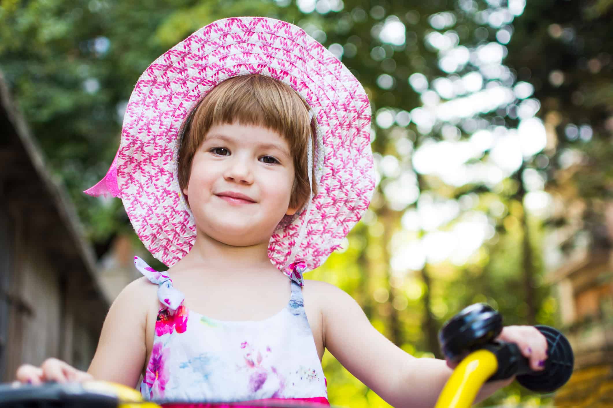 Cute girl learning to ride a bicycle outdoors